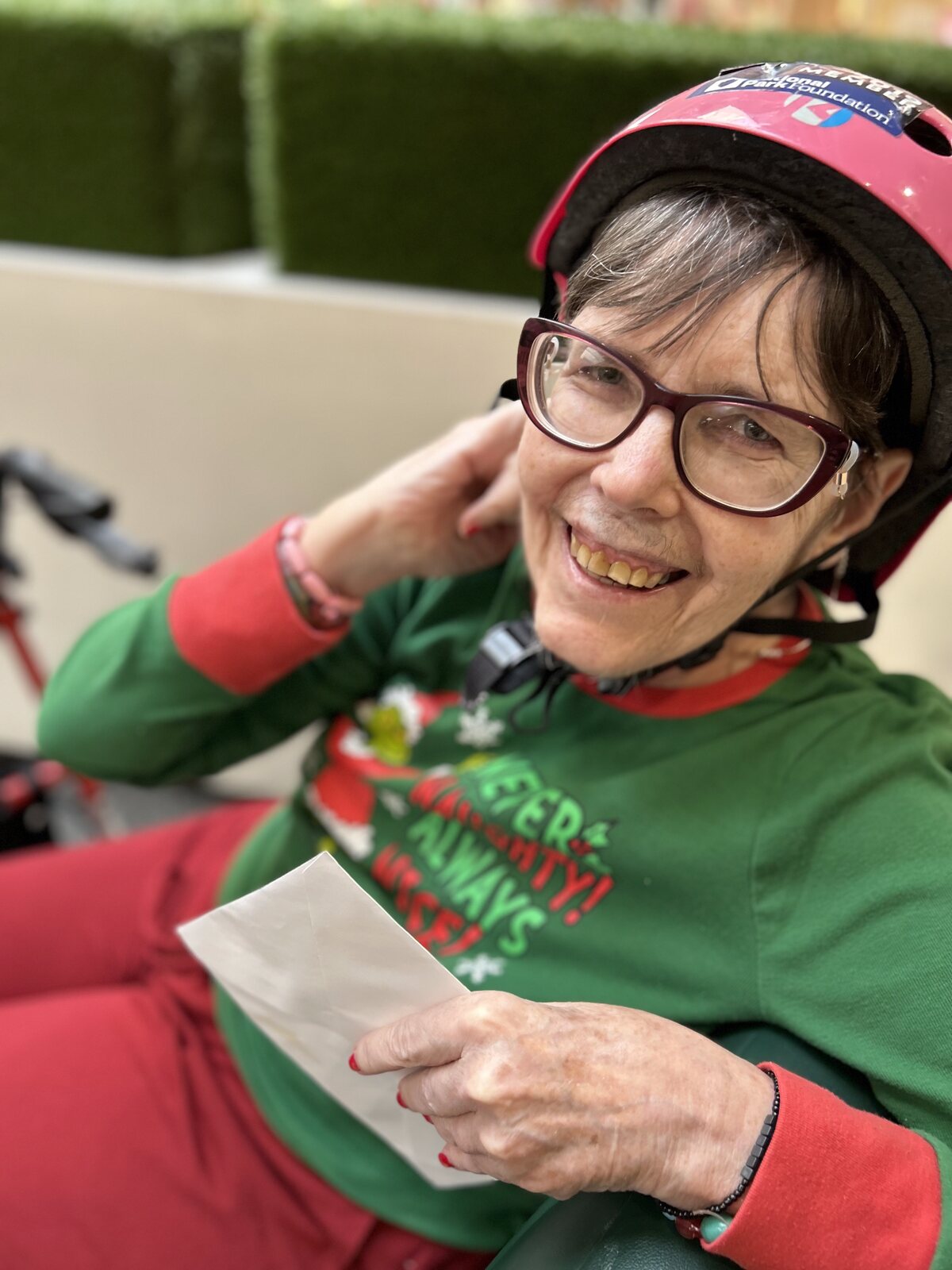 A smiling ATS participant in a festive red hat during a holiday celebration