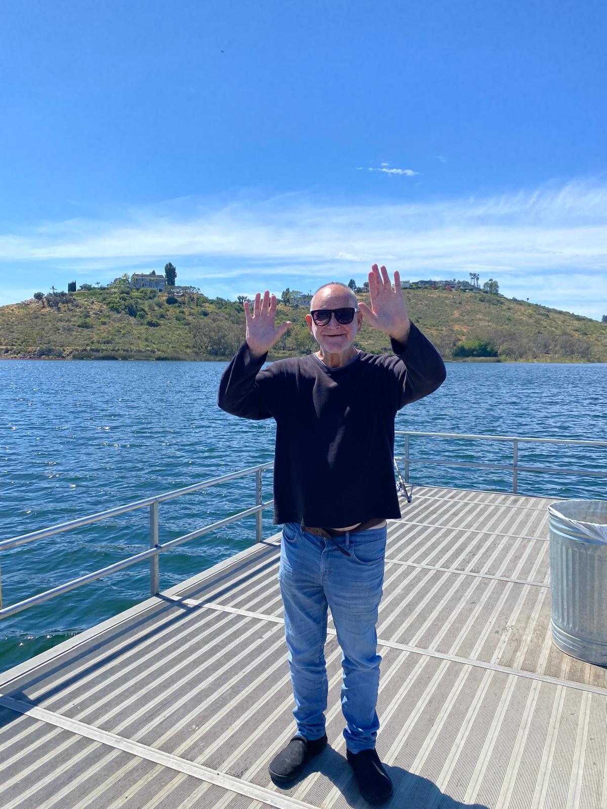 An ATS participant celebrating on a dock by the water